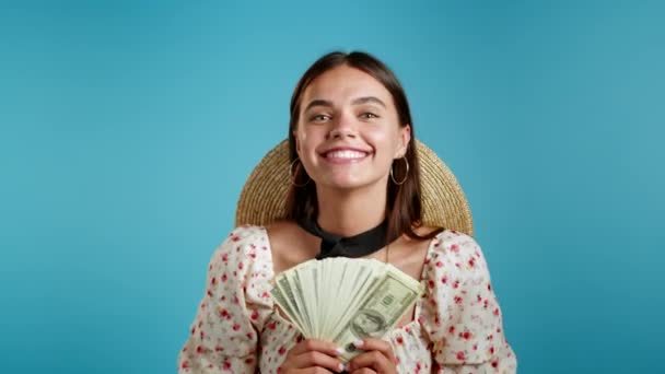Mulher feliz animado incrível mostrando dinheiro notas de dólares da moeda dos EUA na parede azul. Símbolo de sucesso, ganho, vitória. — Vídeo de Stock
