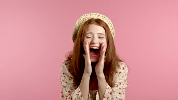 Meisje met rood haar erg blij, ze glimlacht, schreeuwt luid. Vrouw probeert aandacht te krijgen. Concept van verkoop, winstgevend aanbod. Opgewonden vrolijke dame op roze studio achtergrond. — Stockvideo