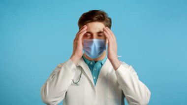 Profesyonel beyaz önlüklü genç doktor yüzünü ölümcül hayal kırıklığından ve başarısızlıktan dolayı elleriyle kapatıyor. Depresyondaki kayıp adam. Drama, duygu konsepti.