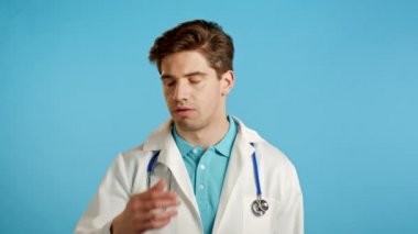 Hüsrana uğramış doktor beyaz giyen adam mavi duvarın arkasından aşınmış. Doktor yorgun, çalışmaktan sıkılmış, hayal kırıklığına uğramış, çaresiz.