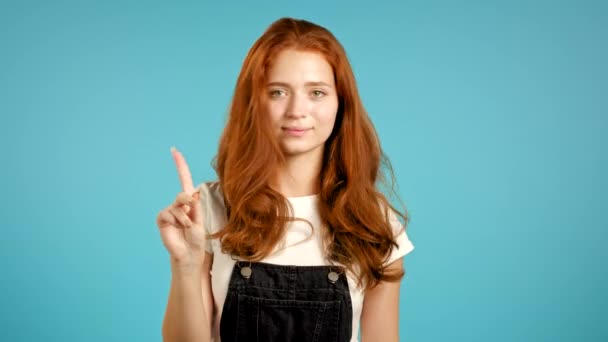 指のサインなしでかなりの女の子は否定的なジェスチャーを作る。拒否,拒否,同意しません,青の背景に女性の肖像. — ストック動画