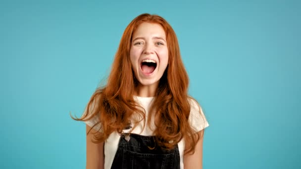 Ragazza con i capelli rossi molto felice, lei urla forte. Una donna che cerca di attirare l'attenzione. Concetto di vendita, offerta redditizia. Eccitato felice signora su sfondo blu studio. — Video Stock