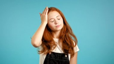 Genç ve yorgun kadın mutsuz. Kızın mavi stüdyo portresi, sıcaktan ya da boğuculuktan nefes veriyor, kollarını kendine sallıyor. Sıcak çarpması kavramı.