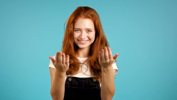 Mooie vrouw die laat zien - Hé jij, kom hier. Meisje in het algemeen vragen om haar te vergezellen, wenkt met uitnodigende handknuffels gebaar. Lady ziet er speels flirterig uit, uitnodigend om te komen. Blauwe studio achtergrond. — Stockvideo