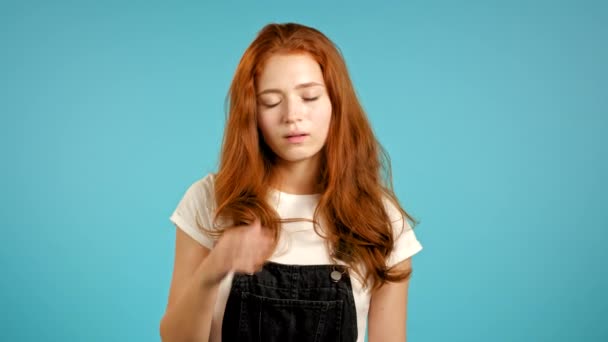 Portrait de jeune femme faisant un geste de facepalm, comme non, j'ai oublié. Femme malheureuse aux cheveux longs éprouvant chagrin, regret, drame, échec. Elle s'est isolée sur un mur bleu — Video