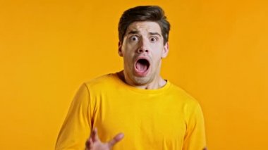 Sarı arka planda yüksek sesle bağıran korkmuş genç adam. Dikkat çekmeye çalışan stresli ve depresif bir adam. Yardım ve güven kavramı