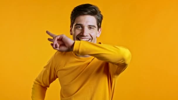 Счастливый европейский мужчина танцует, показывая да жест победы, он достиг результата, целей. Удивленный взволнованный парень на жёлтом фоне — стоковое видео