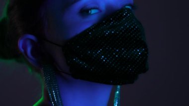Barda ya da kulüpte takma elmaslarla dans eden koruyucu maskeli güzel, modaya uygun genç bir kız. Neon ışıklı seksi kız. Geceleri baştan çıkarıcı gizemli kadın. 