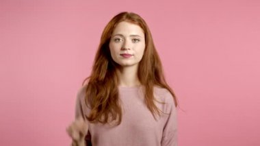 El işaretine hayır diyen güzel bir kadın. Reddetmek, reddetmek, katılmamak, pembe arka planda güzel bir kız ya da öğrencinin portresi
