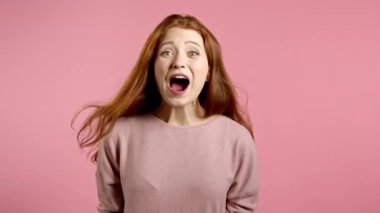 Kızıl saçlı kız çok mutlu, yüksek sesle bağırıyor. Dikkat çekmeye çalışan bir kadın. Satış kavramı, karlı bir teklif. Pembe stüdyo geçmişindeki heyecanlı mutlu bayan..