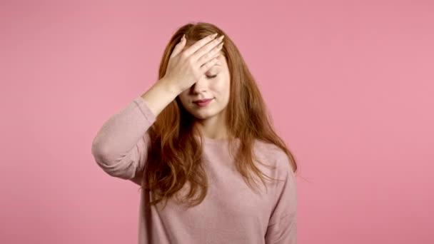 Porträt einer jungen Frau mit Facepalm-Geste, wie nein, habe ich vergessen. Unglückliche Frau mit langen Haaren, die Kummer, Reue, Drama, Versagen empfindet. Sie isoliert sich auf rosa Wand — Stockvideo