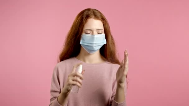 Vrouw met beschermend masker brengt ontsmettingsmiddel antiseptisch aan op haar handen en laat dan zien - het is schoon en steriel. Stop virus concept, bacteriële bescherming. — Stockvideo