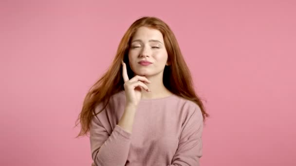 Lächelndes glückliches Mädchen mit Eureka-Geste. Porträt einer nachdenkenden jungen Frau mit Idee, die mit dem Finger auf rosa Studiohintergrund zeigt. — Stockvideo