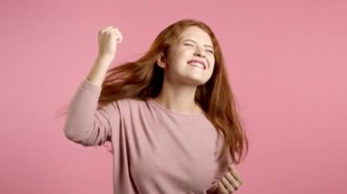 Pembe stüdyo arka planında enerjik ve aktif dans eden güzel bir kadın. Şirin kız. Parti, mutluluk, özgürlük, gençlik kavramı.