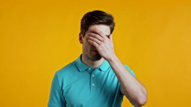 Sarı duvarlı arka planda hayal kırıklığına uğramış Avrupalı bir adam. Adam yorgun, çalışmaktan sıkılmış, hayal kırıklığına uğramış, çaresiz.