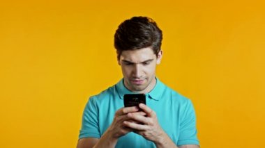 Yakışıklı bir adam cep telefonundan mutlu bir haber alır. Adam şaşkınlık ve sevinçle kendinden geçmiş. Kazandı ve sevindi. Teknoloji, başarı, zafer, mutluluk kavramı.