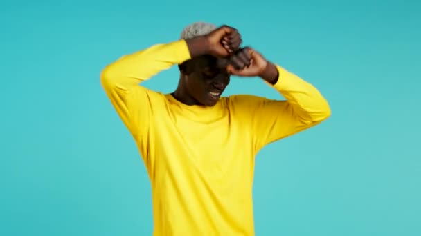 Glücklicher afrikanischer schwarzer Mann, der tanzte, er erreichte Ergebnisse, Ziele. Überrascht aufgeregter Typ auf blauem Hintergrund — Stockvideo