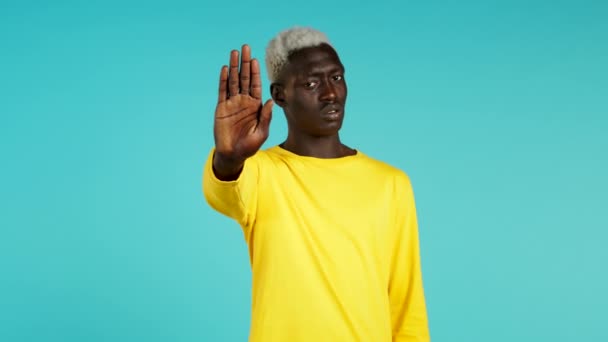 Hombre negro desaprobando sin gesto de señal de mano. Negando, rechazando, en desacuerdo, retrato de chico o estudiante sobre fondo azul — Vídeos de Stock