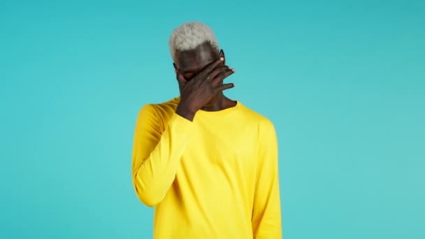 Jonge Afrikaan bedekt zijn gezicht met handen van fatale teleurstelling, mislukking. Depressieve verloren man in t-shirt. Drama, emotie concept — Stockvideo