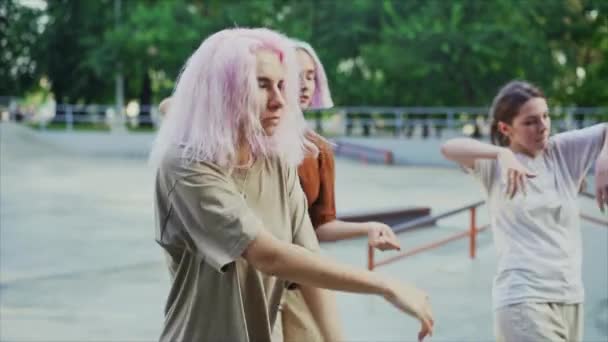 Νεαρά κορίτσια που χορεύουν απολαμβάνοντας φάνκι χιπ-χοπ κινήσεις. Σύγχρονες γυναίκες που εκτελούν ελεύθερο χορό μαζί στο πάρκο skate την ανατολή του ηλίου. Αργή κίνηση. — Αρχείο Βίντεο