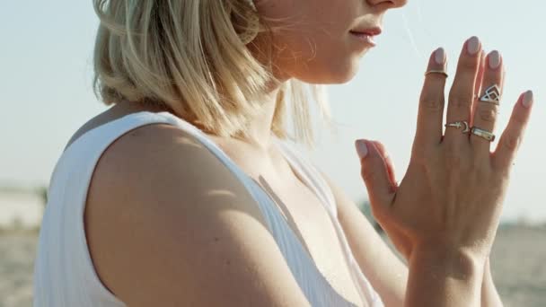 Mujer practicando yoga, namaste gratitud mudra solo en playa de arena a la hora del atardecer de verano. Chica vestida de blanco. Religión, pureza, resignación, concepto de espiritualidad. Movimiento lento — Vídeo de stock