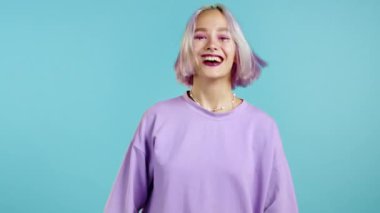 Boyalı menekşe saçlı kadın çok mutlu, yüksek sesle bağırıyor. Dikkat çekmeye çalışan bir kadın. Satış kavramı, karlı bir teklif. Mavi stüdyo geçmişindeki heyecanlı mutlu bayan..