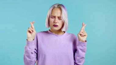 Mor boyalı saçlı, mavi arka plan için dua eden oldukça sıra dışı bir genç kız. Bir kadın birine arzularını tatmin etmesi için yalvarıyor..