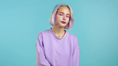 Menekşe saç stili olan kız yorgun, çalışmaktan ya da çalışmaktan sıkılmış, hayal kırıklığına uğramış, çaresiz. Mavi duvar arka planında hayal kırıklığına uğramış Avrupalı kadın. 