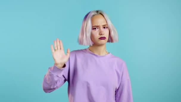有紫色头发的漂亮女人不同意没有手势的手势。拒绝，拒绝，不同意，蓝色背景的漂亮嬉皮士女孩的肖像 — 图库视频影像