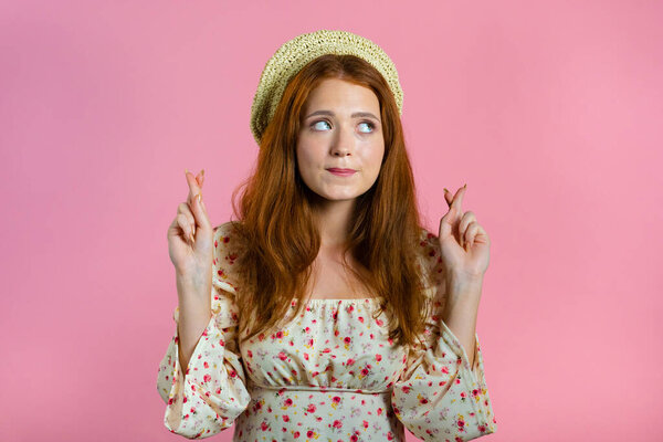 Beautiful woman praying over pink background. Girl in cute outfit begging someone with hope in eyes to satisfy her desires, help with.