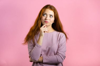 Pembe arka planda yukarı doğru bakan bir kadın. Mutlu gülen yüz ifadeleri. Çekici görünümlü güzel bir model.