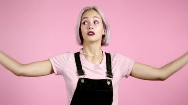 Saçları boyalı, elleri ve pembe arka planda izole edilmiş yuvarlanan gözleri olan tatlı bir kız. Boş vaatler, falan filan. Yalancı..