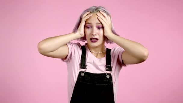 Mujer hipster asustado conmocionado aislado sobre fondo rosa. Chica estresada y deprimida debido a las malas noticias. — Vídeo de stock