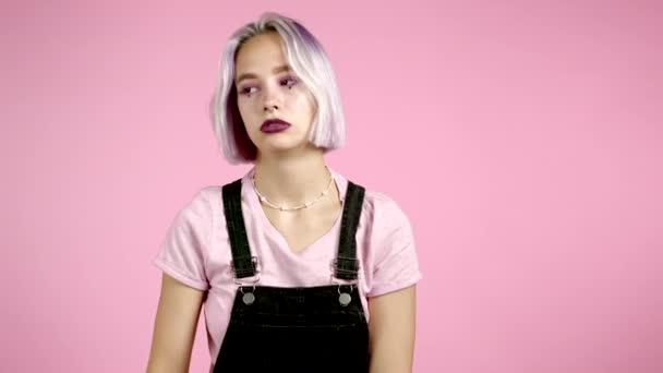 Flicka med violett frisyr är trött, uttråkad på arbete eller studera, hon besviken, hjälplös. Frustrerad europeisk kvinna över rosa vägg bakgrund. — Stockvideo