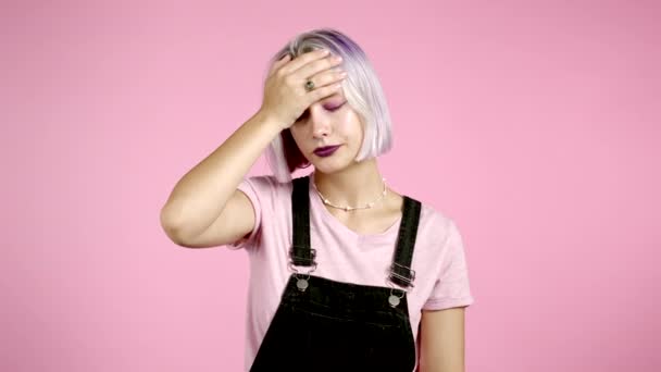Porträt einer jungen Frau mit Facepalm-Geste, wie nein, habe ich vergessen. Unglückliche Frau mit violetten Haaren, die Trauer, Bedauern, Drama, Versagen empfindet. Sie isoliert sich auf rosa Wand — Stockvideo