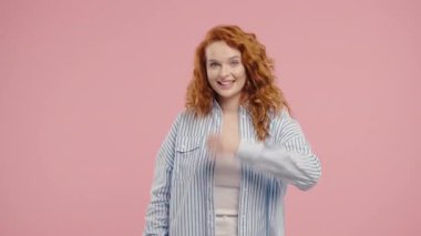 Genç ve güzel bir kadın ona eşlik etmek istiyor. Davetkar bir şekilde el ele sarılma hareketi yapıyor. Güzel bayan arıyor - Hey sen, buraya gel. Oyuncu, davetkar. Pembe stüdyo arka planı