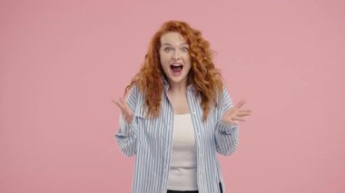 Şaşırtıcı derecede çekici kızıl kadın, vay canına diyor, inanamıyorum. İlgi çekmeye çalışan etkileyici bir bayan. Satış kavramı, karlı bir teklif. Pembe arka planda heyecanlı bir öğrenci kız. Yüksek kalite 4k