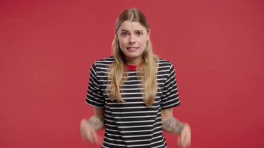 30 'lu yaşlarda güzel bir kadın. Omuzları yukarıda. Yardımcı olamıyor. Zor soru, kırmızı arka planda suçlu tepkisi. Yüksek kalite 4k