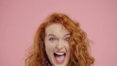 Kendine güvenen kızıl saçlı kıvırcık kadın başarıyı enerjik bir yumruk pompası ve ışıltılı bir gülümsemeyle kutluyor. Başarı, duygusal kazanç, motivasyon, ilerleme, kadın gücü