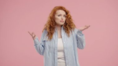 30 'lu yaşlarda güzel bir kadın. Omuzları yukarıda. Yardımcı olamıyor. Zor soru, pembe arka planda suçlu tepkisi. Yüksek kalite 4k