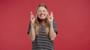 Amerikalı güzel bir kadın dua ediyor, özür diliyor, o suçlu. Kırmızı arka plan. Umut dolu dua eden bayan birinden arzularını tatmin etmesini ve yardım etmesini istiyor. Yüksek kalite 4k