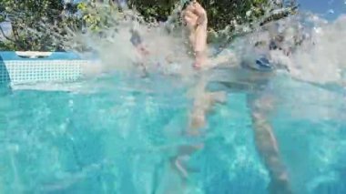 Mutlu küçük çocuklar havuza dalıyor mavi berrak su, çocuklar için eğlence. Yaz yüzüşü, sualtı eğlencesi. Komik çocuklar, dalmanın tadını çıkarın. Aşırı açı. Yüksek kalite 4k görüntü
