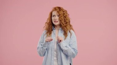 Genç model bir şeyden korkarak şok geçirdi ve pembe arka planda korku dolu büyük gözlerle kameraya doğru bağırdı. Fobi, sorun, panik konsepti. Yüksek kalite 4k görüntü