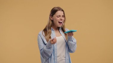 Sinirli bir kadın hoparlörde akıllı telefona bağırıyor ve yoğun tartışmalara tepki veriyor. Çatışma temaları, ilişki draması, iletişim stresi veya duygusal gerilim için harika