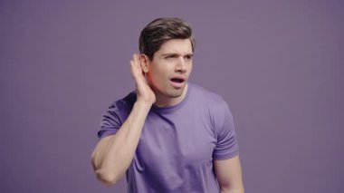 Yakışıklı bir adam, kulağı keskin hareketlerle duyma sorunu ya da kafa karışıklığı gösterir. Ses sorunları, dikkat ipuçları, iletişim eksikliği, sesle ilgili görseller için mükemmel.