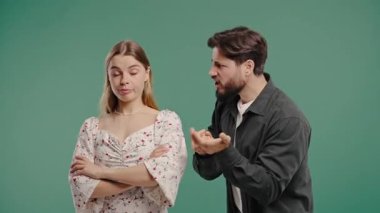 Genç bir adam karısına duygusal olarak bağırıyor ya da yeşildeki kız arkadaşına. Sıkıcı kadın elleriyle bla bla jest yapıyor. Çatışma kavramı, kavga, çift ilişkilerinde sorunlar. Yüksek kalite 4k