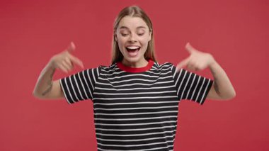 Genç kadın blogcu reklam alanını işaret ediyor. Kırmızı arka plan. Güzel, yetişkin bir kadın aşağıya üye olmak için tıklamak istiyor. Ticari fikir ve tanıtım içeriği için kopyalama alanı. Yüksek kalite 4k