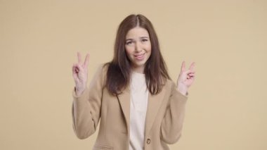 Çekici yetişkin bir kadın, iki parmağıyla bej rengi tırnak işareti, iğneleme. Yüksek kalite 4k görüntü