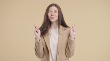 Olgun bir ofis çalışanı resmi giyinmiş parmaklarını çapraz yapar ve sessizce dua eder, beklenti ya da umudu ifade eder. Şans, önemli sonuçlar, iş riskleri, profesyonel hayattaki yüksek bahisli anlar.