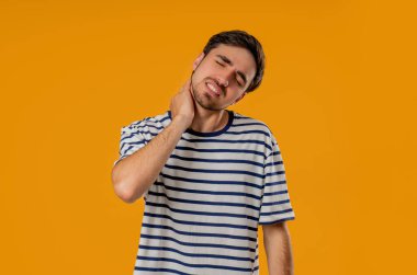 Yorgun genç bir adam boyun eklemlerinde ağrı hissediyor, kaslara masaj yapıyor, başını ovuyor. Eklem iltihabı yüzünden rahatsızlığı olan adam. Sağlık hizmeti, tıbbi konsept